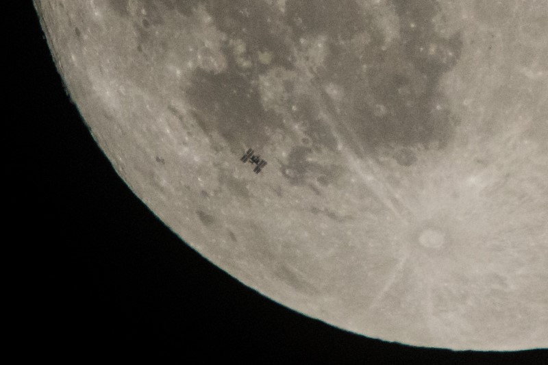 Die ISS von der Erde aus fotografiert, mit dem Mond als Hintergrund